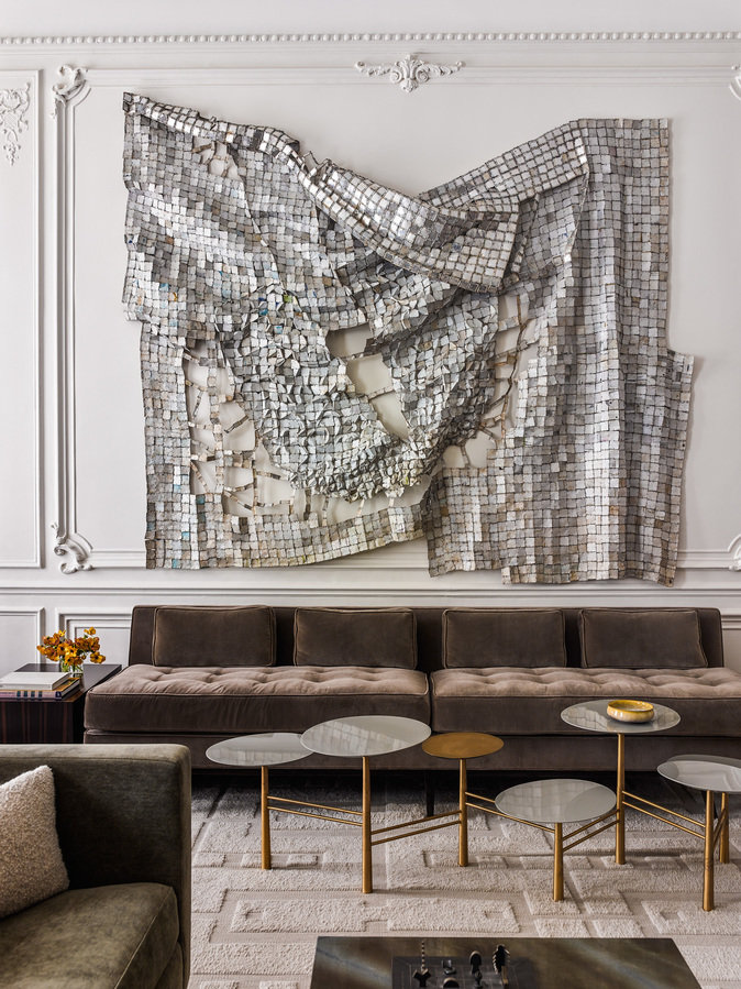 Prewar living room with modern sofa in brown velvet, tiered coffee table in metal and lacquer, metal fabric wall hanging.