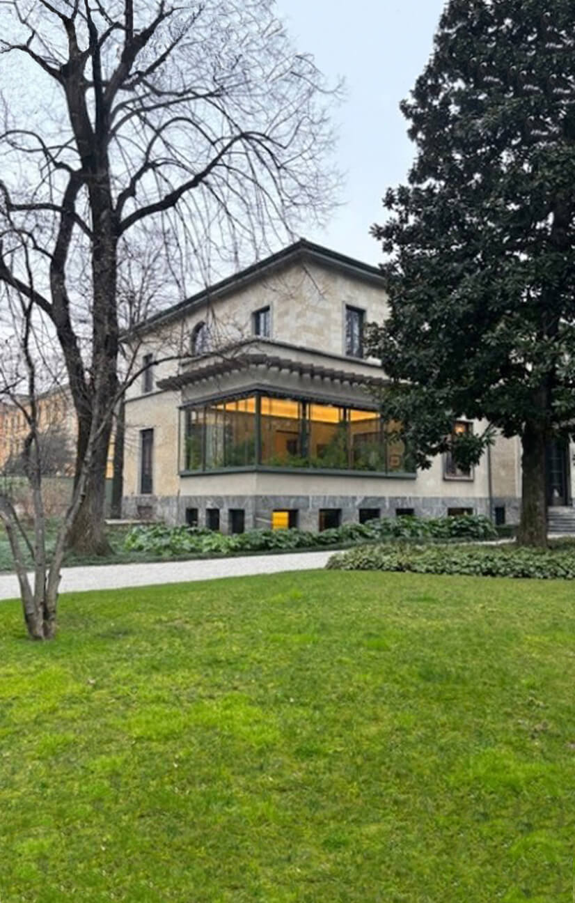 An exterior shot of Villa Necchi showing the veranda, with a lawn in the foreground.