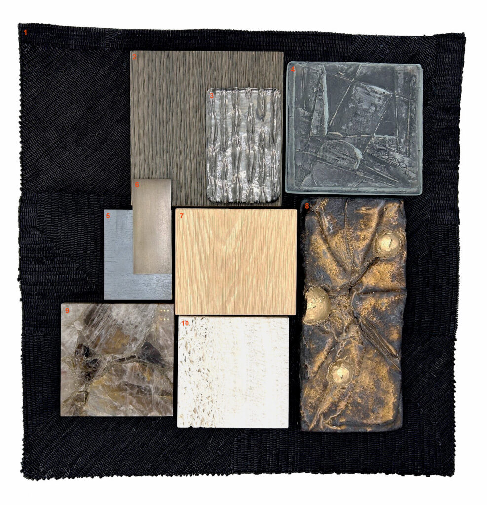 A black, woven rug with a collection of stone, wood, glass and ceramic samples arranged on top.