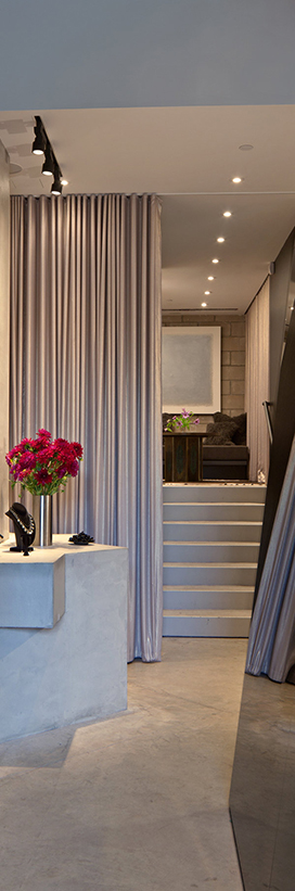 Retail space with concrete floor, concrete stairs and concrete display, and a silver curtain in the background.