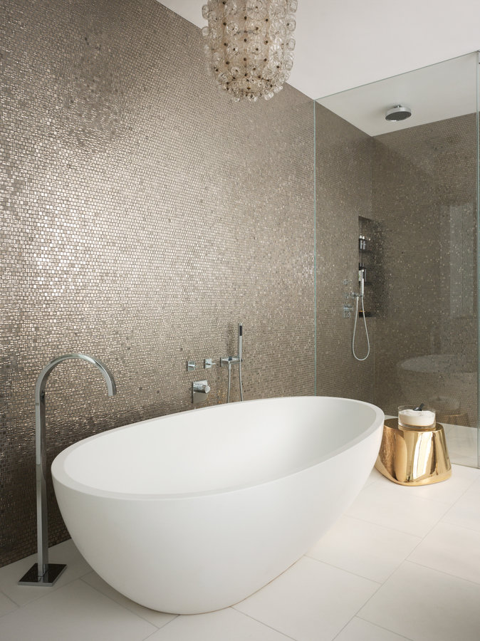 Platinum mosaic tile wall, antique glass ceiling light, white soaking tub with floor mount spout and glass shower enclosure.