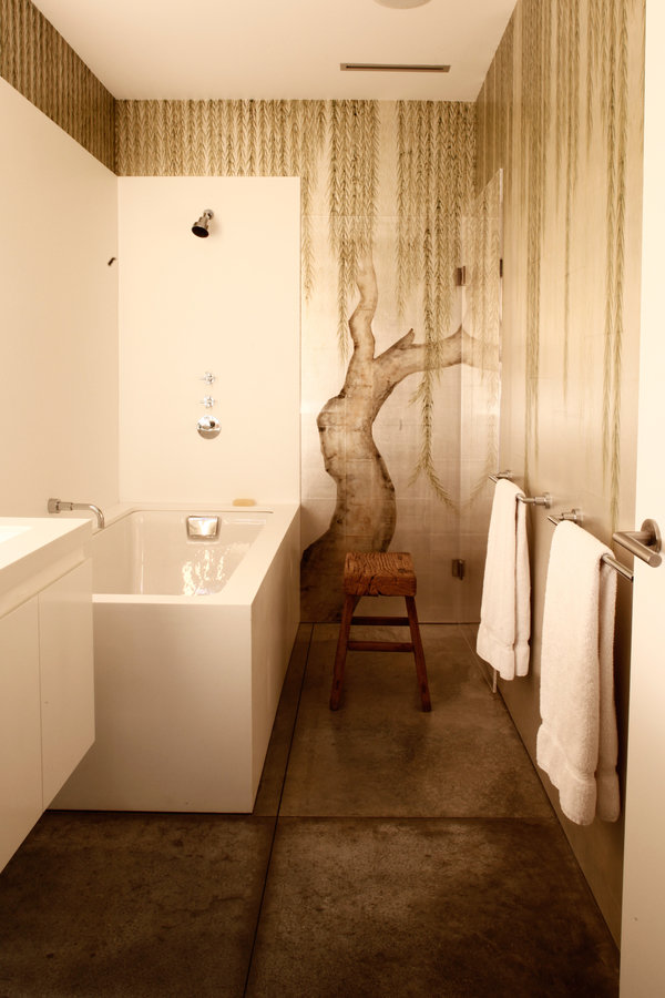 Modern bathroom with weeping willow wall mural, white lacquer vanity, white soaking tub, wood stool and concrete floor.